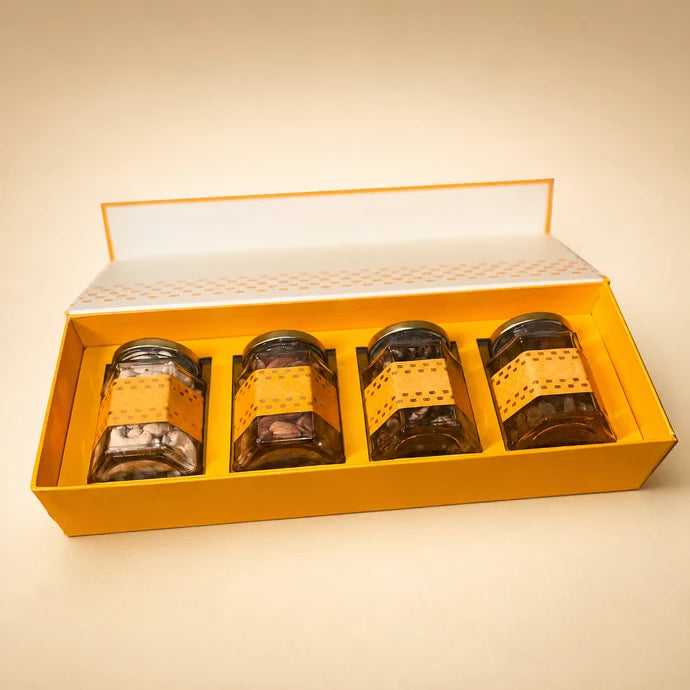 MM Mithaiwala Box Full Of Yum, a closed yellow and white rectangular gift box with a central floral motif.