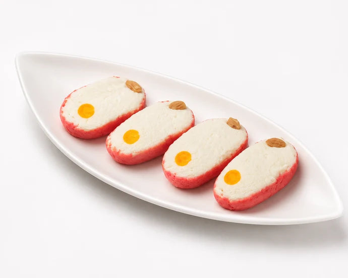 MM Mithaiwala Chhena Toast sweets with pink sides, white topping and almond garnish, arranged on a white platter.