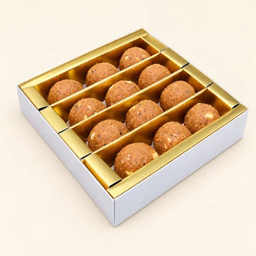 MM Mithaiwala Churma Laddu Box with brown laddus arranged in a gold compartment tray.