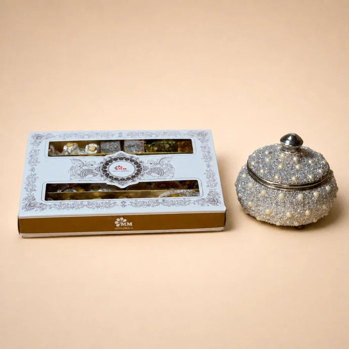 MM Mithaiwala Jashn mithai box with white and gold packaging and two long windows displaying assorted sweets.