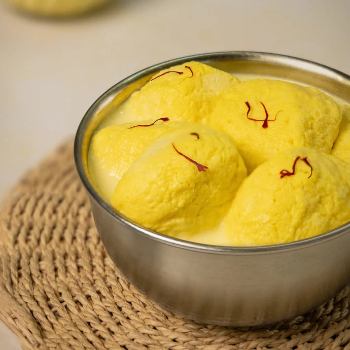 MM Mithaiwala Kesar Rasmalai in saffron-coloured milk, garnished with saffron strands in a metal bowl.