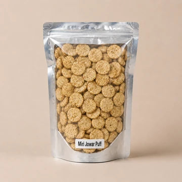 MM Mithaiwala Miri Jowar Puffs in a silver pouch showing speckled round puffs through its clear front.