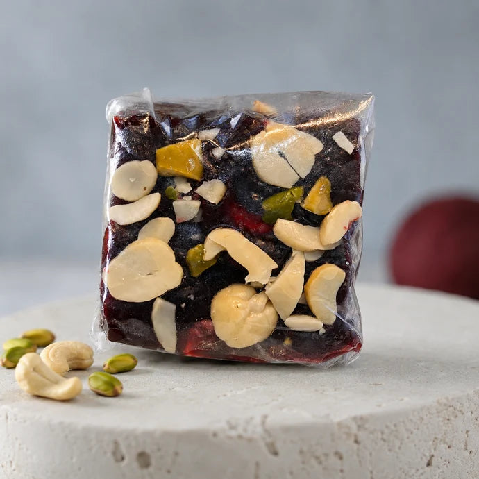 MM Mithaiwala black Badami Halwa piece from the 500g mix, individually wrapped with visible cashews and pistachios.