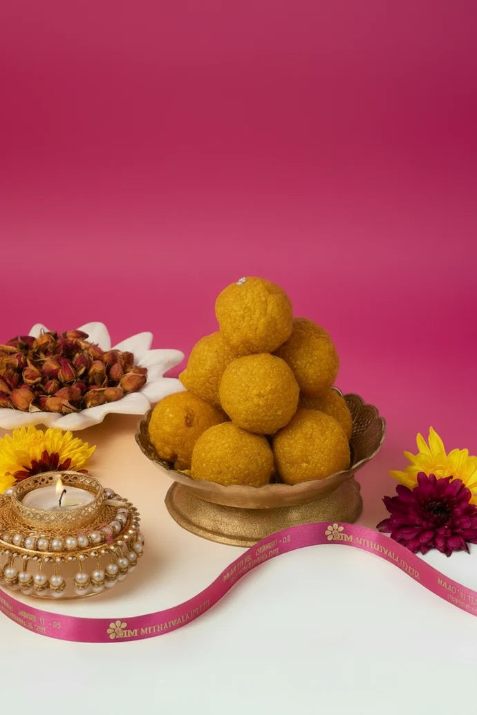 MM Mithaiwala Motichur Laddu stacked on a cream plate with saffron strands and pistachios alongside.