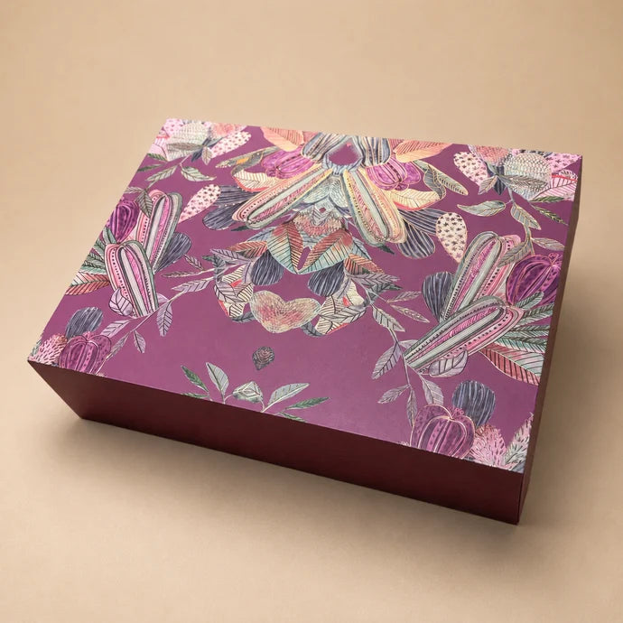 MM Mithaiwala Pink Paradise, a closed mauve gift box with colourful botanical illustrations.