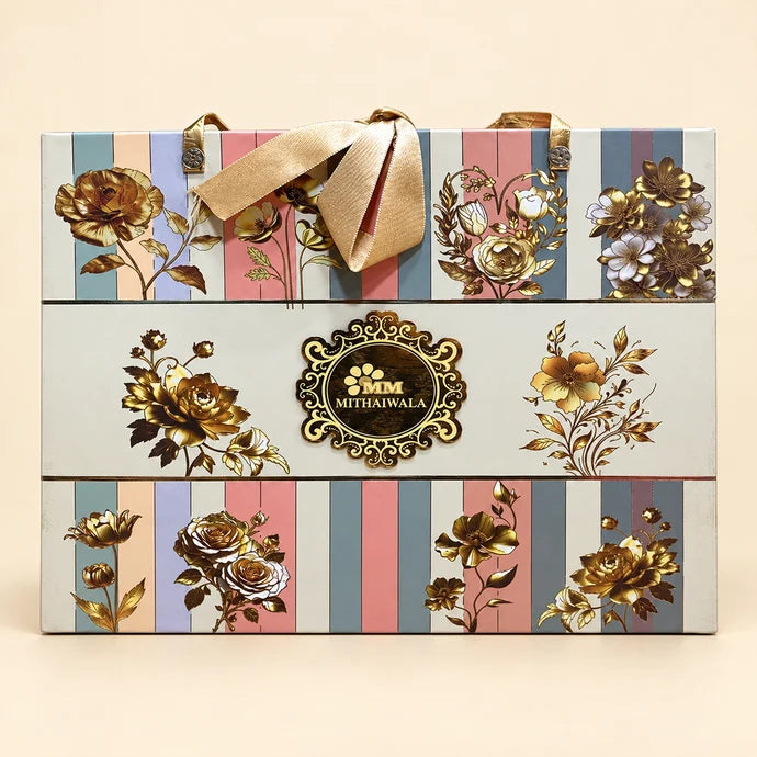 MM Mithaiwala Purse Hamper with pastel stripes, golden floral motifs, ribbon handles and a central brand label.