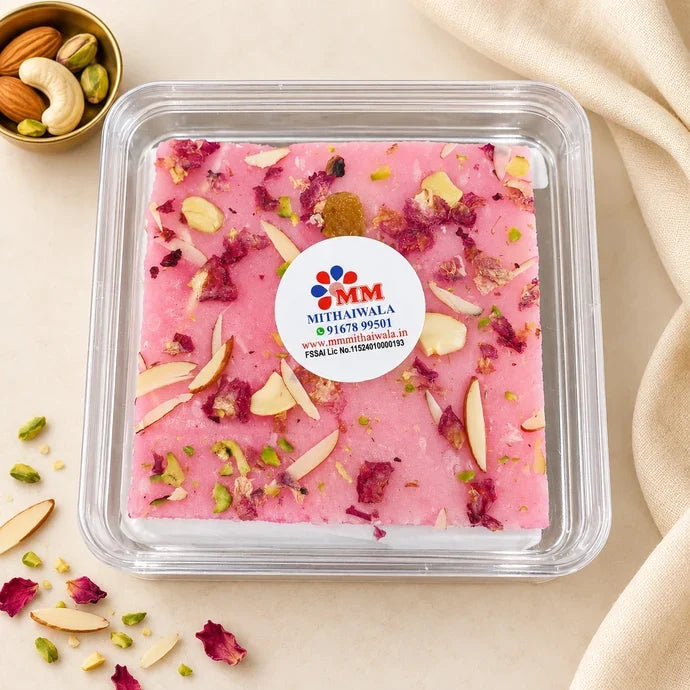 MM Mithaiwala pink Rose Ice Halwa topped with sliced nuts and rose petals in a closed clear container with a branded label.