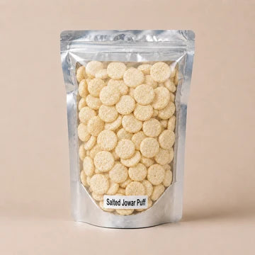 MM Mithaiwala Salted Jowar Puffs in a silver resealable pouch with a clear front, against a beige background.