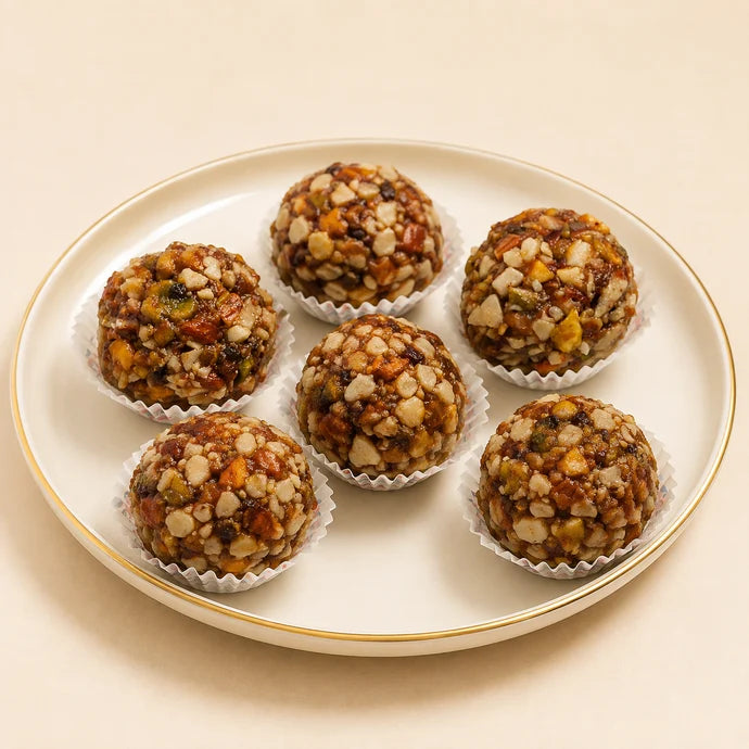 MM Mithaiwala Sugar Free Gulkand Dry Fruit Laddu with visible mixed nuts, arranged in paper cups on a white gold-rimmed plate.