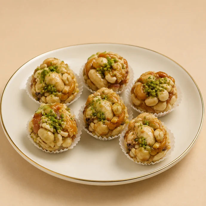 MM Mithaiwala Sugar Free Jardalu Laddu with visible cashews and apricot pieces, topped with pistachios on a white gold-rimmed plate.