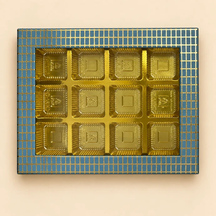 MM Mithaiwala The Pearl Edit Blue 12 Cavity Box with assorted sweets in golden compartments and a blue and gold grid-patterned border.